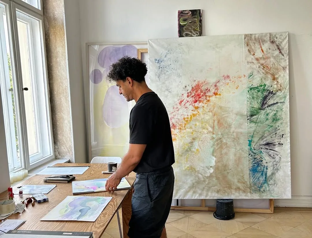 Odey Curbelo trabajando en su estudio junto a varias obras